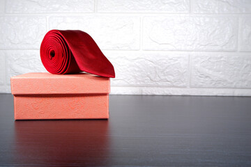 red tie rolled with gift box closeup view 
