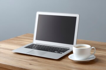 Fototapeta premium Silver Laptop and Coffee Cup on Wooden Desk: Minimalist Office Scene