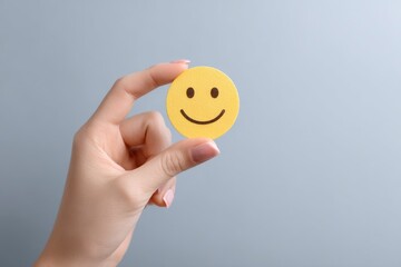 Hand Holding a Cheerful Yellow Smiley: A Minimalist Image of Happiness