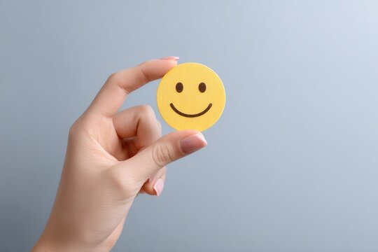 Hand Holding a Cheerful Yellow Smiley: A Minimalist Image of Happiness - Powered by Adobe