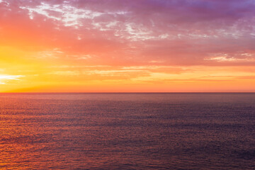 Fototapeta premium beautiful sunrise or sunset seascape with amazing calm sea water with waves and colorful amazing cloudy morning sky on background