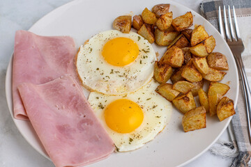   fried eggs with sliced ham and home fries
