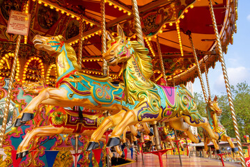 Horses of an old fashioned carousel ride in fairground, England, UK