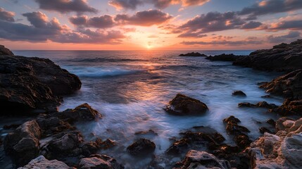 Fototapeta premium Vibrant sunset over rocky coastline ocean waves
