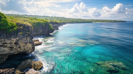 Obraz premium A breathtaking view of a rocky coastline with turquoise water and lush greenery, under a bright blue sky with scattered clouds.