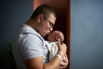 Obraz premium Young father and his newborn son at home