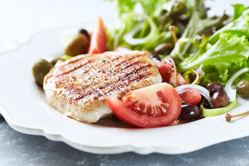 Grilled Turkey Breast with fresh salad. Bright background.	