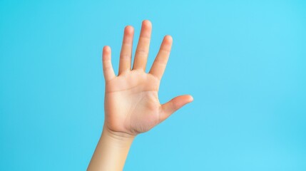 A child's hand with five fingers raised in the air against a blue background.