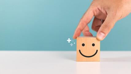 Satisfaction, service rating and positive feedback concept. A man choose wooden cube with smile...