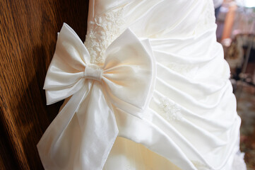 Elegant White Wedding Gown with Decorative Satin Bow Details..
