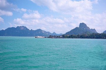 Fototapeta premium Scenic View of Tropical Island With Turquoise Waters and Distant Mountain Landscape..