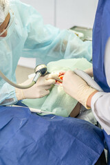 Two dental professionals perform a procedure on a patient in a clinical environment, focused and attentive to details