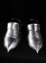 Detailed Close-Up of Historical Metal Foot Armor on Black Background