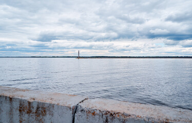 Serene Coastal Scene with Lighthouse Under Cloudy Sky..