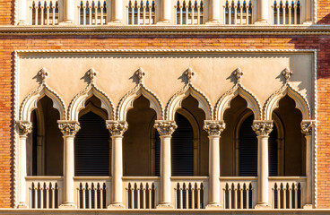 Close-up view of a historic building facade in Italy, showcasing its detailed stonework and arched windows. Background of european architecture and travel concept