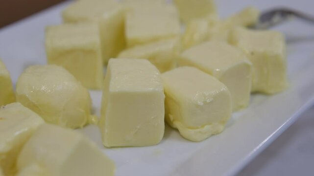 Pieces of fresh butter on white textured table, closeup. Space for text. High quality photo