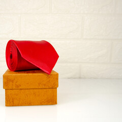 A red tie rolled on gift box closeup view 