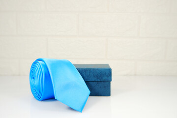 A blue tie rolled with gift box closeup view gift concept 