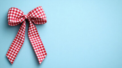 a red gingham plaid ribbon bow tied vector on soft light blue background, clean and minimalistic banner design with space. Festive/Holiday Decoration.