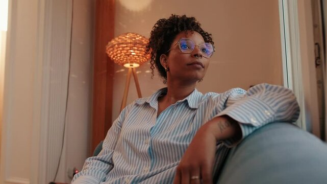 Thoughtful Woman Gazing Out Window in Cozy Apartment