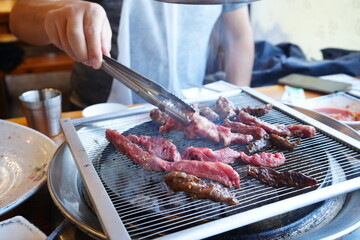 Man cooking Korean BBQ, Sliced Raw Beef Meat on Black Grill Plate - 韓国 焼肉 肉を焼く男性	