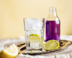 Refreshing lime tonic with vibrant purple soda in a glass with ice, creating a striking contrast that evokes a sense of freshness and bold visual appeal, perfect for beverage promotions