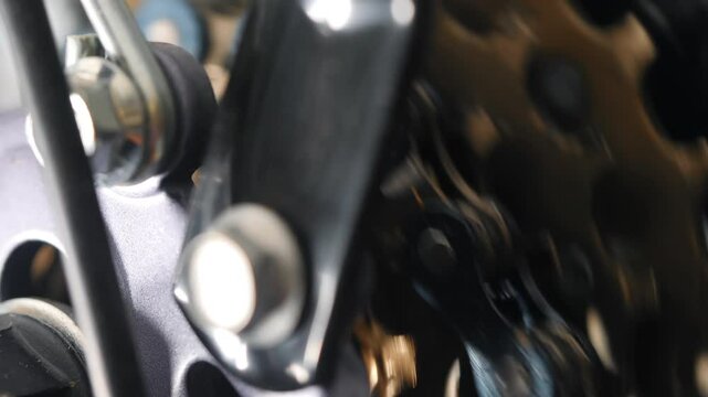 Bike gear system with chain and cogs macro shot.
Video footage of bicycle drivetrain components showing chainring, derailleur, and gear mechanism in extreme close-up with shallow depth of field.