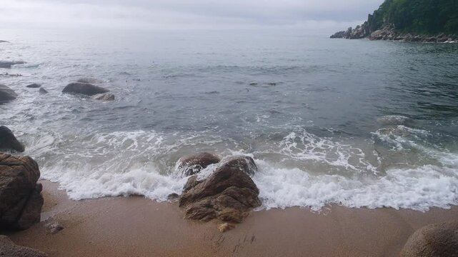 The coast of the Sea of Japan with coastal water-worn rocks, beach scarp. klip, rocky islets (skerry), seacoast erosion, Eastern Siberia, Primorsky Krai. Nakhodka
