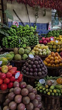 Colorful tropical fruits on display at Funchal&rsquo;s market in Madeira &mdash; showcasing local flavors like passion fruit, bananas, mangoes, and pitanga.