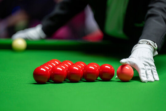 A snooker referee places balls on the table with pinpoint accuracy