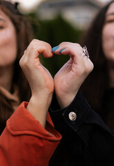 Fototapeta premium Two women making a heart with their hands. LGBT symbol