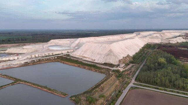 Aerial View of Massive White Phosphogypsum Waste Heaps from Fertilizer Production with Sediment Pools and Forest Landscape in Lithuania