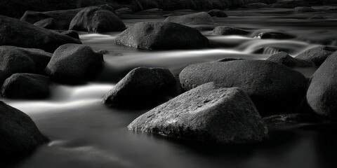 Water flows around dark rocks in a river at daytime