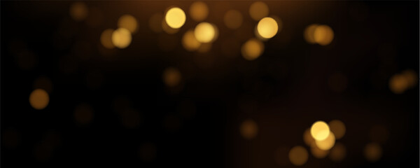 Golden bokeh light effect glowing on dark background. Glittering light texture at night for celebration, party or Christmas.