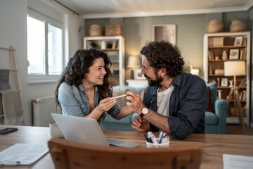 Fototapeta premium Happy couple sharing pregnancy test result at home