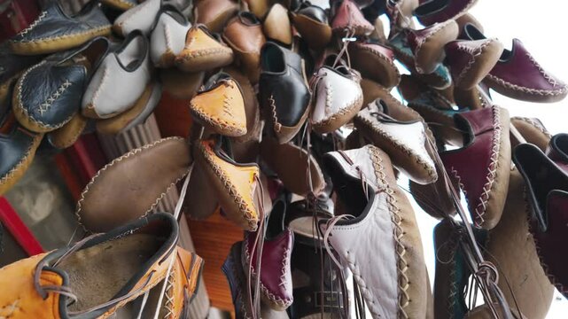 Traditional Turkish leather shoes or slippers are on display. These handmade shoes made of natural leather in different colors attract attention with their sewing details and simple designs.