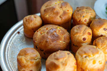 Freshly baked traditional bread rolls displayed on a silver platter in a cozy kitchen setting