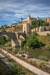 Vertical Scenery of Architectural Monument during Sunny Day in Toledo. Puente de Alcántara is a Roman Arch Bridge in Spain. Landmarks with Tagus River in Europe.