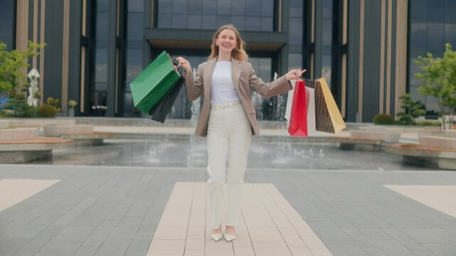 Trendy woman with bags smiling after a successful shopping spree
