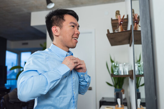 A young man getting dressed for work