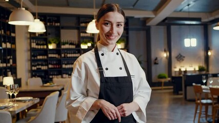 Confident chef smiling in modern restaurant kitchen during busy dinner service