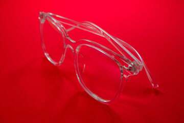 transparent eye glass closeup shot on red background 