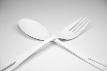 Fork and spoon together on white background close-up view 