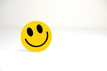 Smiling emoji face closeup view with white background with copy space 