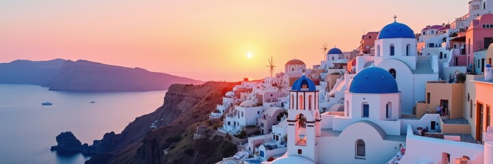 Fototapeta premium Breathtaking sunset over Santorini, featuring iconic white buildings with blue domes, perfect for travel, tourism, or lifestyle promotions.