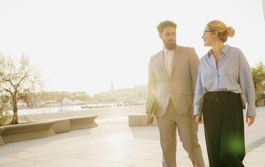 In an Urban Setting, a Professional Couple is Walking at Sunset, Enjoying Togetherness