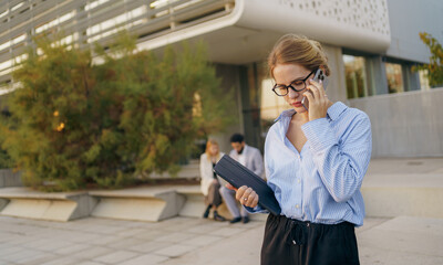 A professional woman on a phone call in a modern urban setting, highlighting career aspects