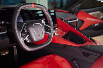 Closeup of a modern car steering wheel with control buttons for technology and convenience