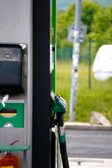 A fuel pump station with multiple nozzles hanging in place, photographed up close in natural daylight.

