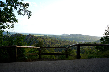 A serene nature reserve featuring rugged cliffs and dense forest, capturing the untouched beauty of...